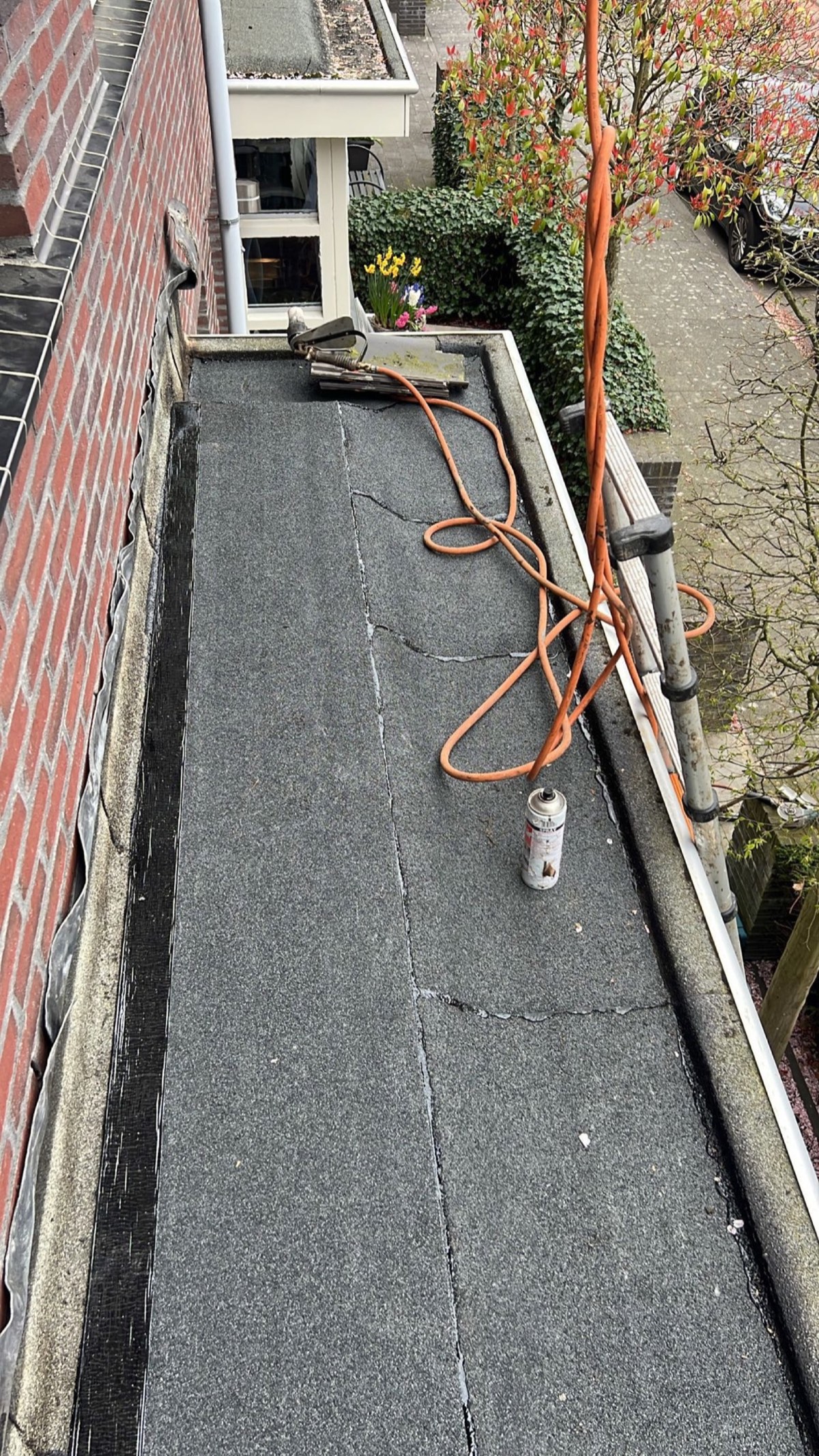 Dakdekker bezig met reparatie plat dak